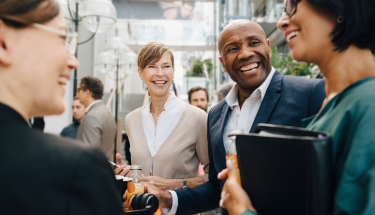 A group of people in business attire laughing